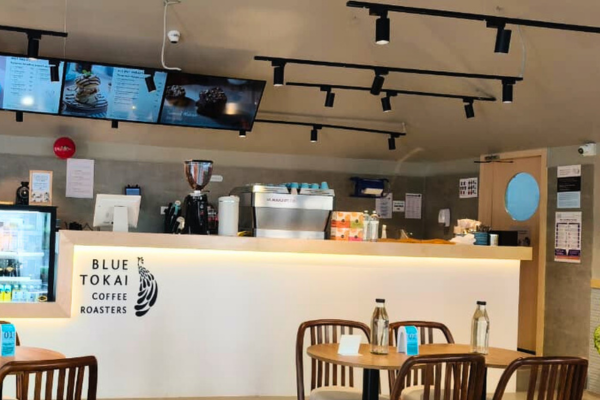 Showcasing a vibrant Blue Tokai outlet, this collection illustrates the premium quality of retail space developed by Infinity Group. From the modern glass interiors and sleek service counters to the relaxing open-air seating zones, these images define the high standard of our shops for rent. For businesses seeking visibility and ambiance, this location offers an exceptional retail space for rent, perfectly blending contemporary architecture with a welcoming customer experience.